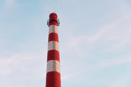 Red and white chimney on a blue sky backgroundの写真素材