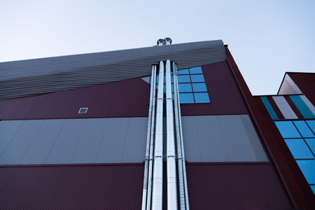 A burgundy building with pipesの写真素材