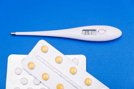 Drops, pills, lekartva and thermometer on a bright backgroundの写真素材