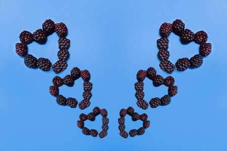 Heart laid out of a blackberry on a blue backgroundの写真素材