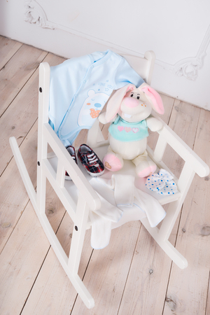 A highchair with toys and clothes for the child. Slips, body, bootiesの写真素材