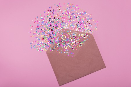 A craft envelope with sparkles on a pink backgroundの写真素材