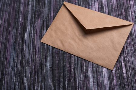 Envelope of Kraft paper. Love letter envelope. Wooden background. Envelope with hearts. Social network.の写真素材