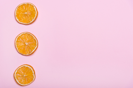 Pieces of orange. Circles with orange. Pink background. Citrus fruits. Fruits on a pink background. Pink Lavender.の写真素材