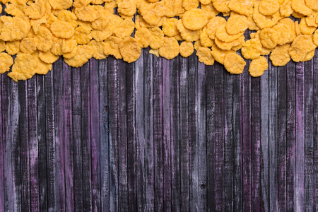 Flakes on an ironic background. multicolored background. Useful zatrak. Yellow flakes scattered on a wooden background. Place for the inscription. Place for text.の写真素材