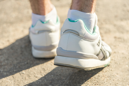 A man in sport sneakers walking on asphaltの写真素材