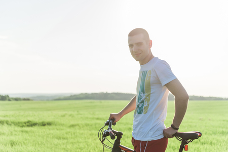 A man standing next to a bicycleの写真素材