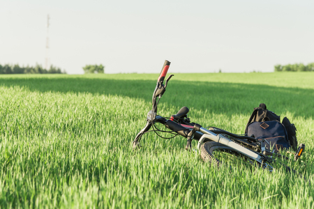 Bicycle on the grass with backpacksの写真素材