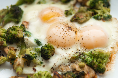 Fried eggs with broccoli and chicken meat. Healthy breakfast. Breakfast on a white plate.の写真素材