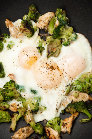 Fried eggs with broccoli and chicken meat. Healthy breakfast. Breakfast in a pan.の写真素材