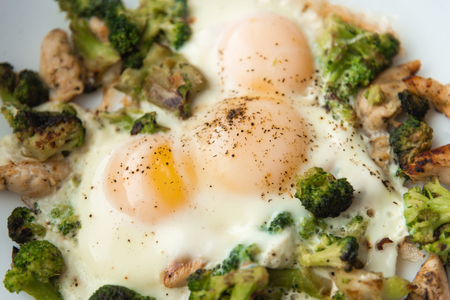 Fried eggs with broccoli and chicken meat. Healthy breakfast. Breakfast on a white plate.の写真素材