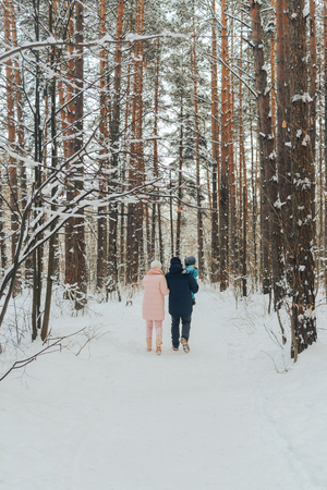 Walking family with a child. Family walks in nature in winter. Winter family walk in nature. A lot of snow. Snowy forest.の写真素材