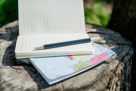 planning travel. Map, note and pencil on wooden background.の写真素材