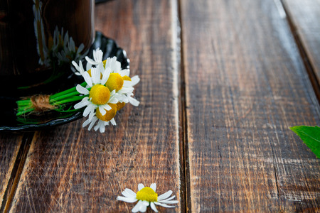 black cup of tea with chamomile on wooden table background. Tea concept. Frame, copy space. Closeupの写真素材