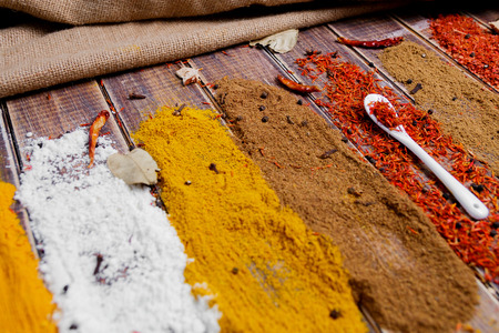 White spoon with saffron near different colorful spices on wooden background.  Various spices selection. Closeup.の写真素材