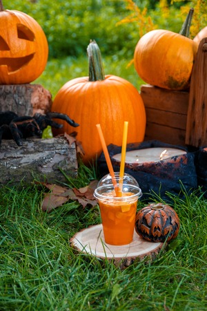 Halloween cocktail with pumpkins decoration on background. Punch for a partyの写真素材