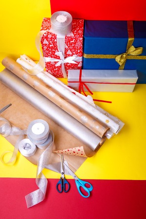 Gift wrapping, boxes, paper, ribbon and scissors on color background. Materials and accessories for wrapping presents. Close up.の写真素材