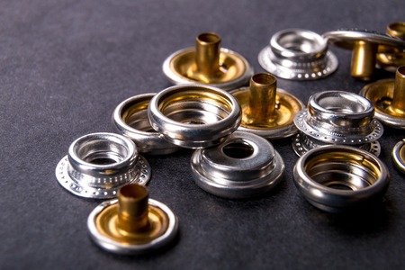 Detail for metal buttons for clothing on black background. Close up.の写真素材
