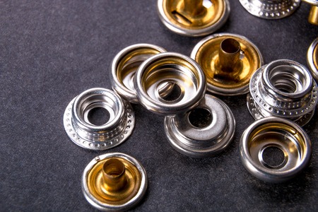 Detail for metal buttons for clothing on black background. Close up.の写真素材