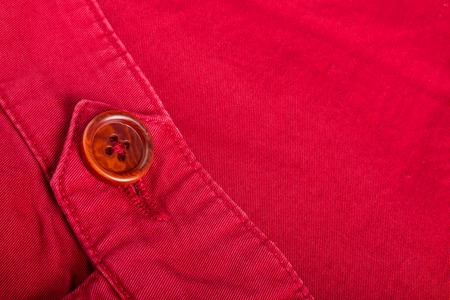 Fragment of red button on cotton twill material. Close up.の写真素材