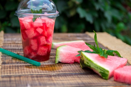 Watermelon cocktail with slice on wooden background, outdoors.の写真素材