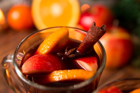 Close up of Christmas mulled wine with fruits, candles  and spices background. Winter warming drink with recipe ingredients. Top view.の写真素材