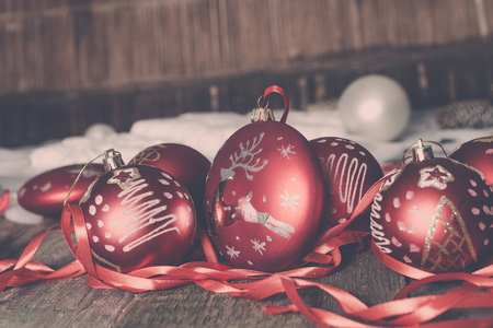 Red Christmas ball and ribbons on wooden background. New year card.の写真素材