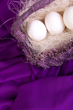 Easter. White eggs in purple basket on violet background.の写真素材