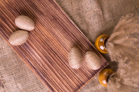 Easter eggs in twine on brown wooden stand on sackcloth background. Rusticの写真素材