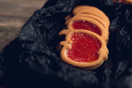 Cookie, biscuits filled with red raspberry jam on black table background. Top view, copy space.の写真素材