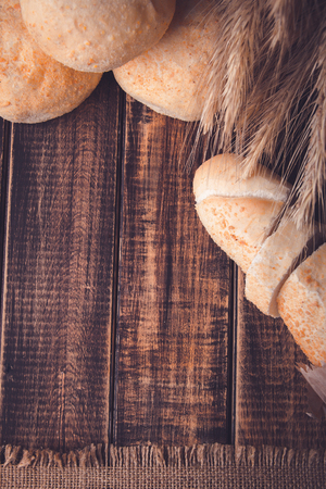 Different kind of freshly baked bread on a rustic wooden table near wheat. Healthy eating concept. Copy spaceの写真素材