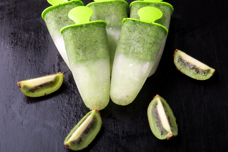 Green homemade ice cream on black background. Fruit ice with kiwi.の写真素材