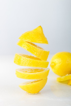 Flying lemon. Sliced lemon on white background. Levity fruit floating in the airの写真素材