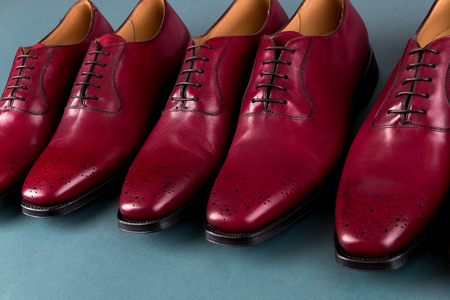 Red oxford shoes on blue background. Three pair  broguesの写真素材