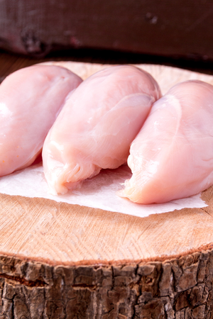 Raw chicken fillet on wooden background. Close up.の写真素材