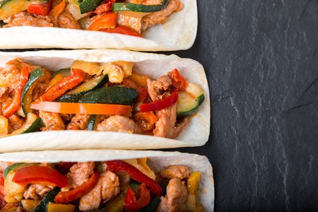 Mexican tacos with pork and vegetables. Al pastor taco on slate tableware. Top viewの写真素材