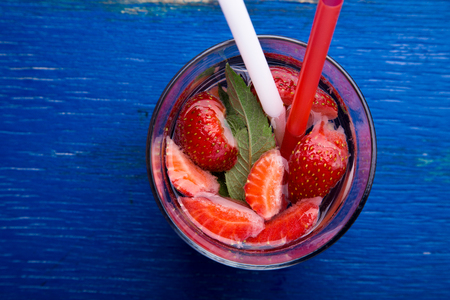 Strawberry mint detox water in glass on blue background. Diet. Top viewの写真素材
