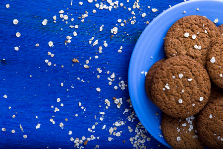 Oatmeal cookies on blue plate on blue wooden background. Top view. Copy spaceの写真素材