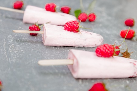 Raspberry ice cream on grey background. Three popsicles. Homemade