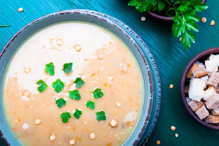 Pea soup in green bowl on green wooden background. Top view. Dry yellow pea. Vegan foodの写真素材