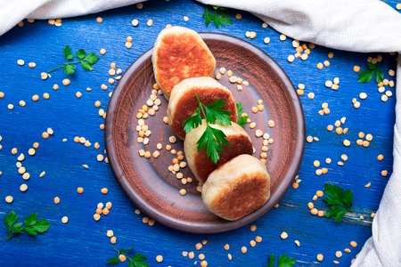 Roasted pea patty in brown plate on blue wooden background. Top viewの写真素材