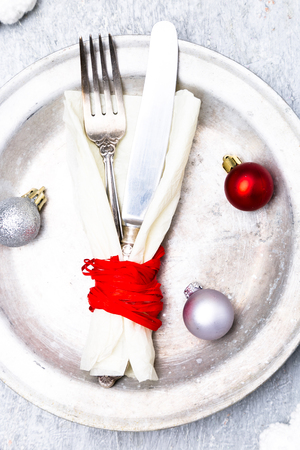 Christmas table place setting. Holidays background. Silver plate, knife and fork with christmas decorations. Top viewの写真素材
