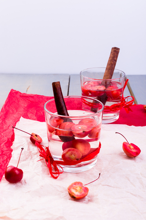 Detox apple cinnamon water on red pepper and wooden background. の写真素材
