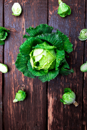 Fresh green cabbage big and small on wooden background. Top view. Copy space. Flat layの写真素材