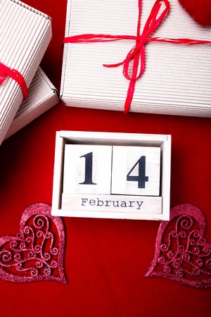 Wooden calendar show of February 14 with red heart and gift boxesの写真素材