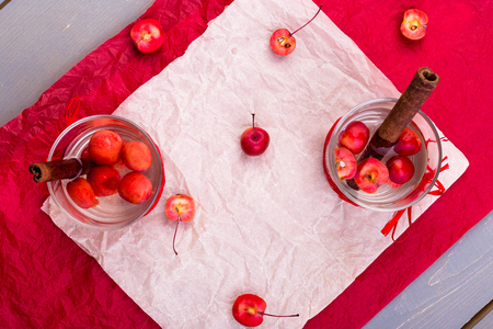 Detox apple cinnamon water on red pepper and wooden background. Top view. Flat layの写真素材