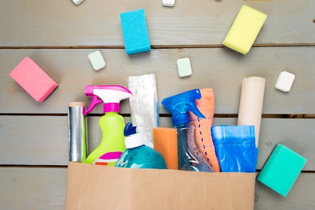 Full paper bag of different house cleaning product on wooden tableの写真素材