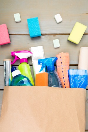 Full paper bag of different house cleaning product on wooden tableの写真素材