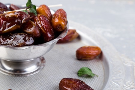 Dry fruit dates on silver tray. Copy space. Close up
