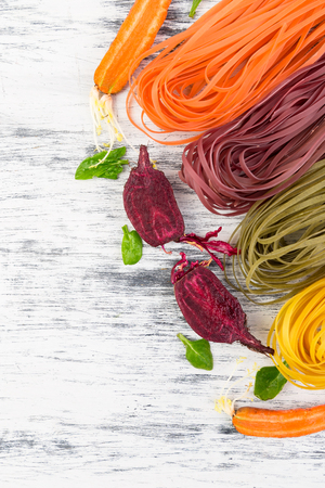 Colored Raw Vegetable Vegetarian Pasta with Beets, Carrots and Spinach. Flat lay. Copy space. Top view. Frame.の写真素材